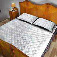 White quilt with two pillow shams, black piping, and embossed diamond crosshatch pattern