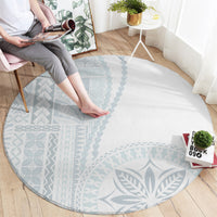 Round light-gray carpet with blue tribal pattern and bordered design