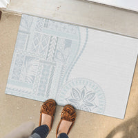 Rectangular rubber doormat, white with light blue pattern, shown with shoes