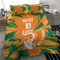 Orange and green geometric bedding set with elephant graphic and two pillows on gray floor