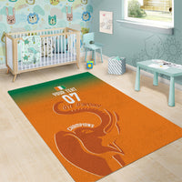 Orange area rug with elephant design and sports lettering on a rectangular shape.