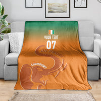 Custom football blanket on a couch, orange-to-green with elephant and Champions text