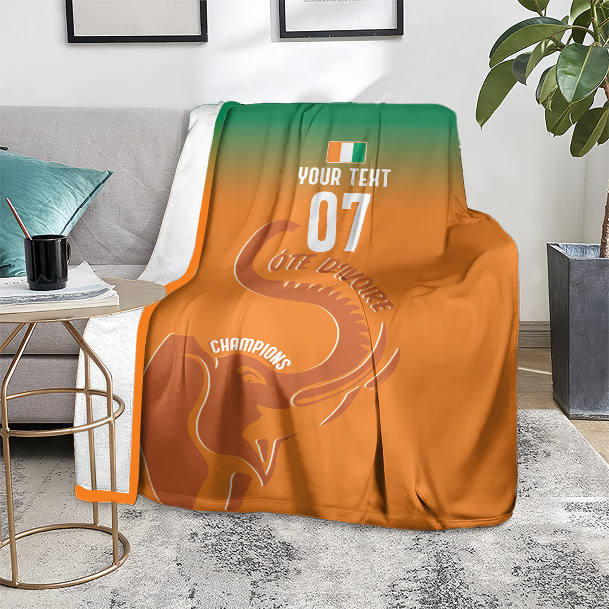 Custom football blanket on floor, orange-to-green with elephant graphic and Champions text