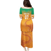 Orange long football jersey dress with green upper and elephant graphic back, number 07
