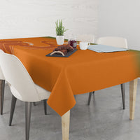 Orange tablecloth on dining table with sports emblem print and curved decorative lines