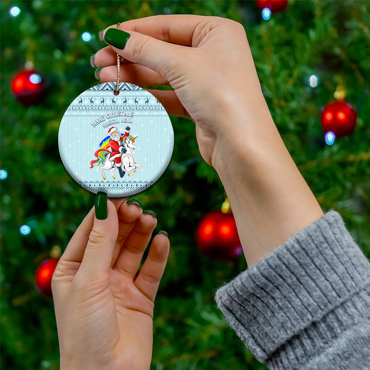 Turquoise round ceramic Christmas ornament with unicorn and Santa, held by hand