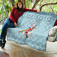 Turquoise quilt draped over sofa with unicorn rider graphic, diamond quilting and festive trim