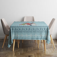 Turquoise Christmas tablecloth featuring unicorn artwork across the tabletop