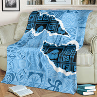 Turquoise blanket throw featuring a white-edged island silhouette and blue patterns