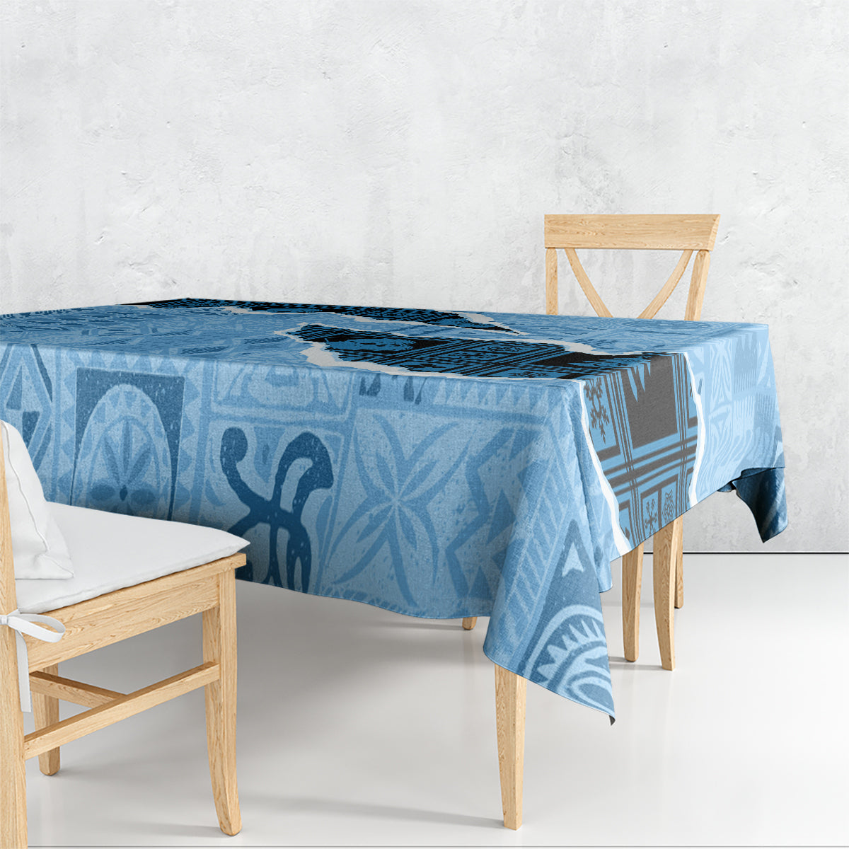 Turquoise tablecloth with blue geometric and tiki-inspired motifs, draped over table