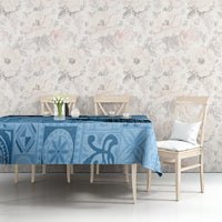Turquoise tapa-style tablecloth with light and dark blue motifs across the tabletop