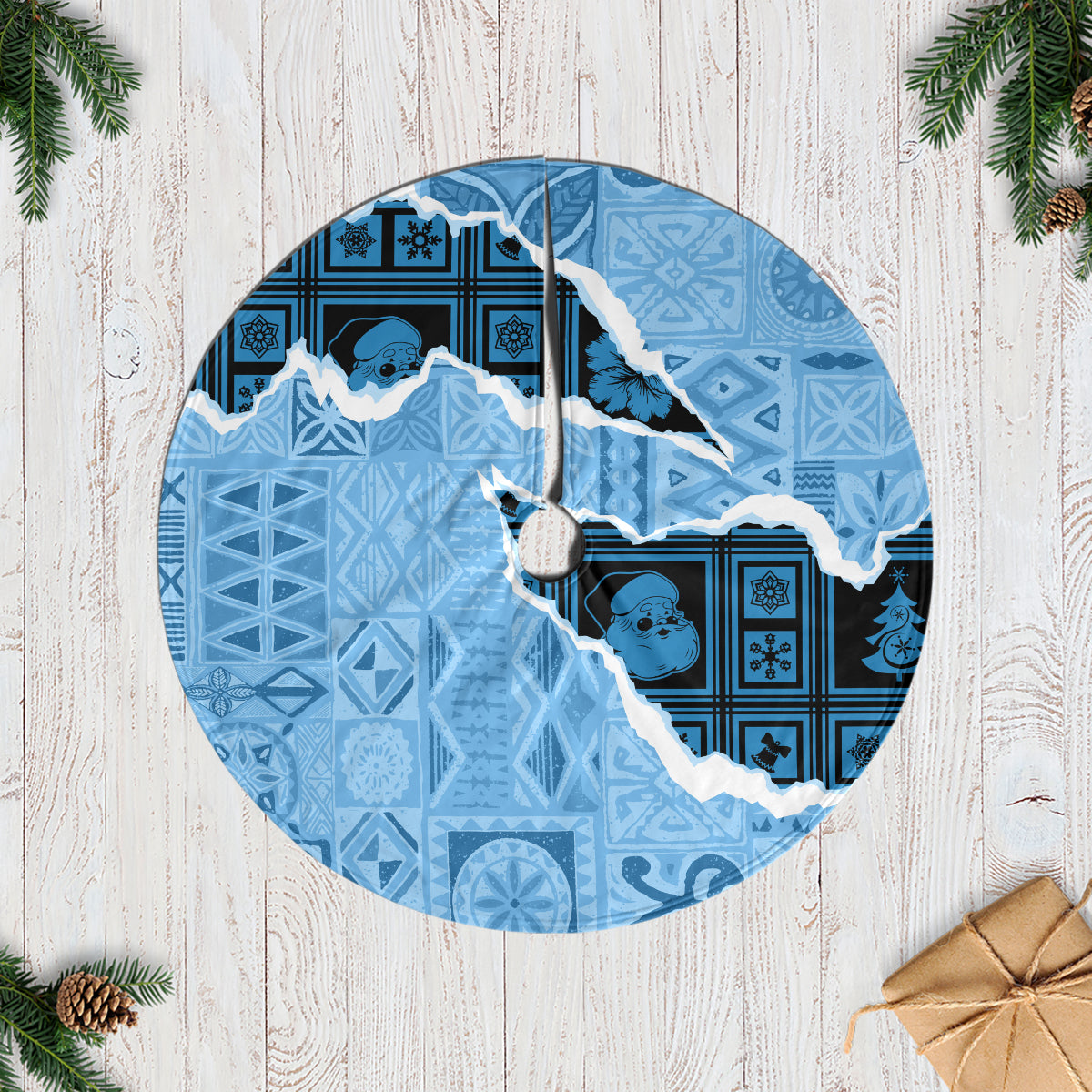 Turquoise round Christmas tree skirt with navy tapa-style patches and white fringed edge