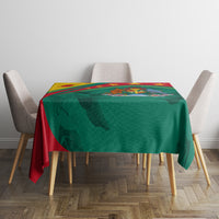 Green tablecloth with red border and yellow-trimmed design, centered on dining table