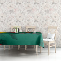 Green tablecloth with red edge and star motif on dining table with chairs