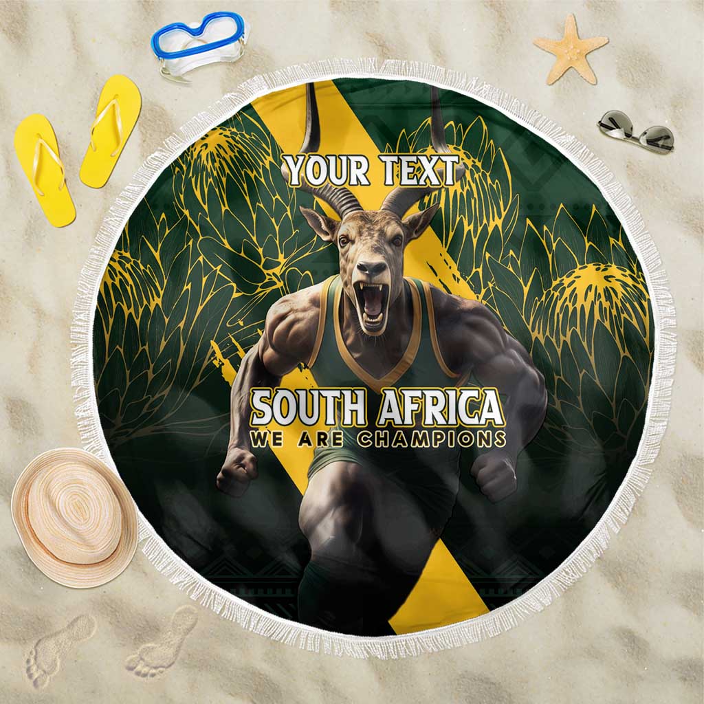 Round dark green beach blanket with tassel fringe, South Africa champions text and mascot