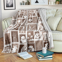 Brown patchwork throw blanket with square tropical-themed designs, folded over an armchair