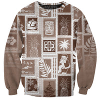 Brown crewneck sweatshirt with patchwork Christmas-themed icons and long sleeves