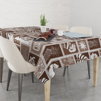 Brown retro patchwork tablecloth with festive icons on dining table surface