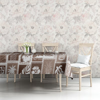 Brown patchwork tablecloth with festive retro motifs on table against a light wall