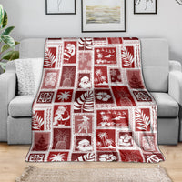 Red patchwork Christmas blanket draped over sofa, featuring square novelty prints and plants