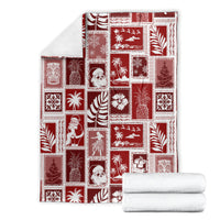 Red patchwork Christmas blanket displayed with white stacks, square holiday print design