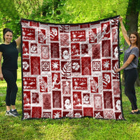 Red patchwork holiday quilt hanging outdoors with white motif squares