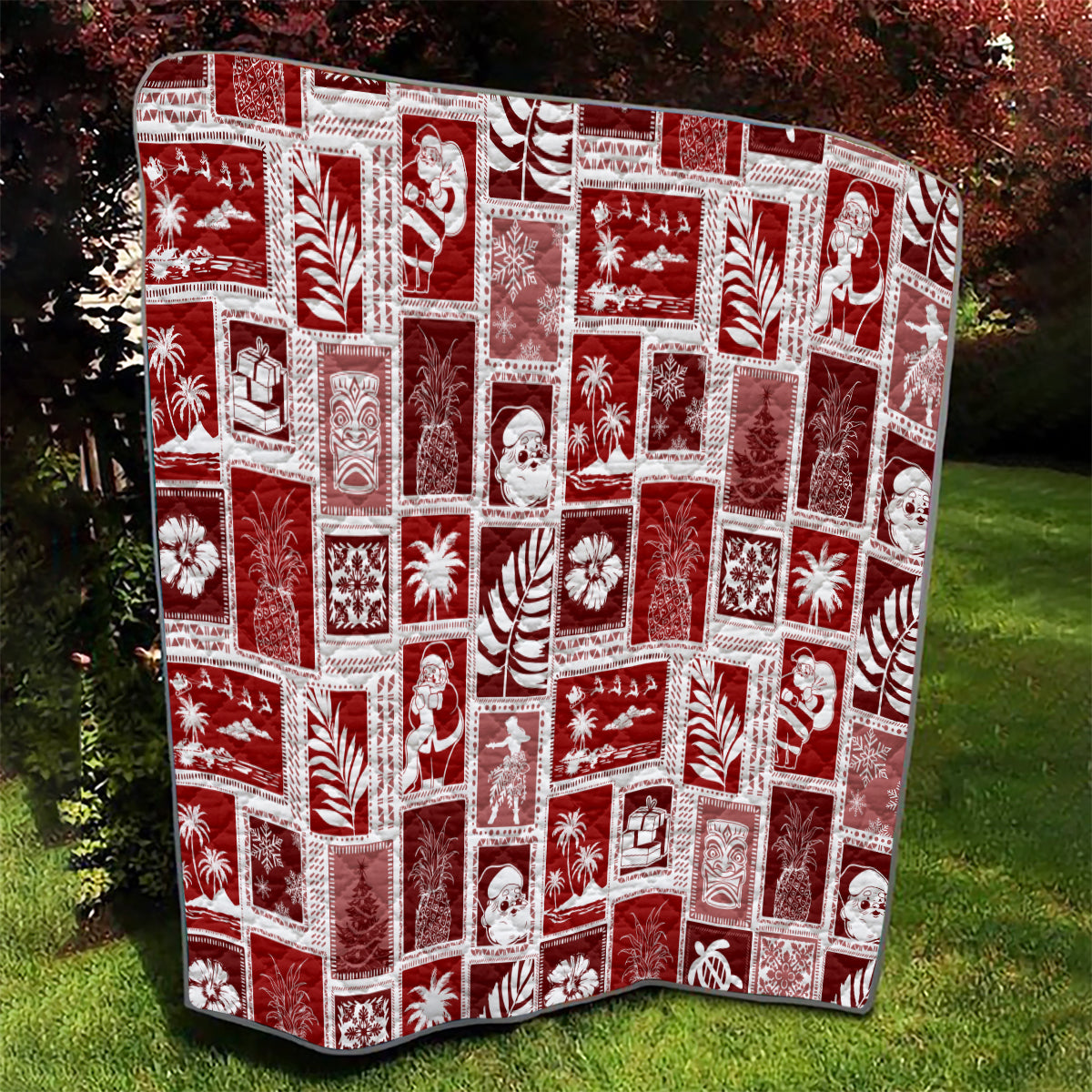 Red patchwork quilt with white holiday pattern squares, shown outdoors