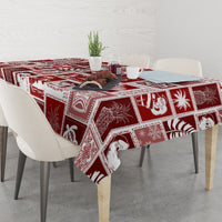 Red patchwork tablecloth with white festive motif panels on dining table