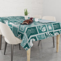 Teal and white patchwork tablecloth with tropical prints, draped over dining table