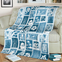 Aquamarine patchwork throw blanket draped over sofa, featuring blue-and-white holiday and leaf motifs