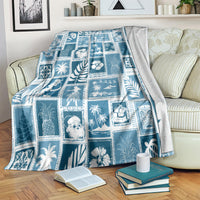 Aquamarine patchwork blanket with blue-and-white holiday and palm leaf designs, folded edge