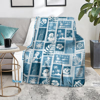 Aquamarine patchwork throw blanket with blue-and-white holiday figures, palms, and ornaments