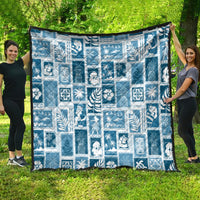Aquamarine patchwork quilt draped outdoors, white holiday-themed block pattern with trim.