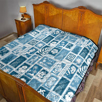 Aquamarine quilt on bed with white square patchwork design and holiday-themed prints.