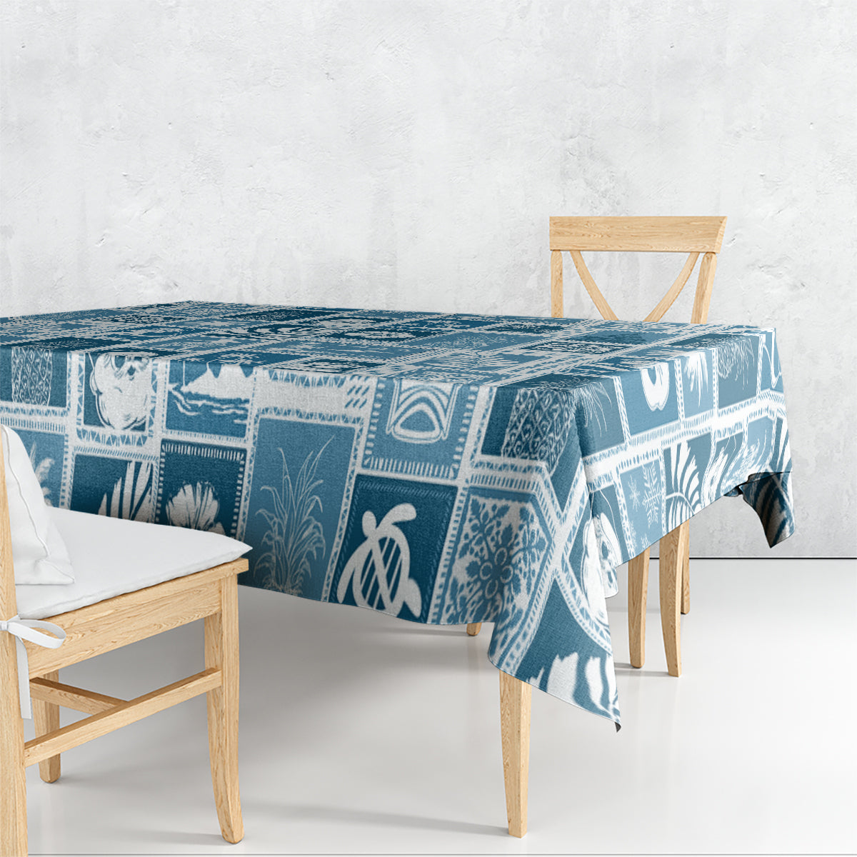 Aquamarine blue patchwork tablecloth draped over dining table, tropical icon pattern