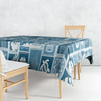 Aquamarine blue patchwork tablecloth draped over dining table, tropical icon pattern