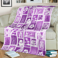 Violet patchwork Christmas blanket with festive square tiles, draped over a sofa