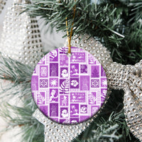 Violet ceramic round ornament hanging from pine branches, gold loop and patchwork design.