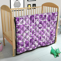 Violet Hawaiian patchwork quilt on a wooden crib, white printed patch blocks
