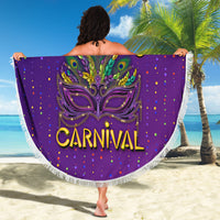 Purple round beach blanket with fringe, Carnival mask graphic and Mardi Gras text, held up at beach.