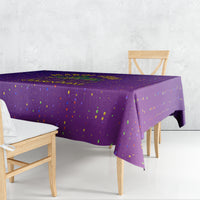 Purple confetti-dotted tablecloth draped over a dining table with corner drop.