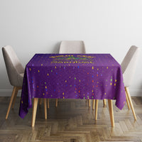 Purple confetti-dotted tablecloth covering a square table with overhang on all sides.