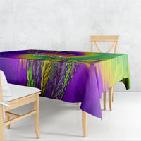 Tie-dye tablecloth draped over table with purple, green, and yellow feather pattern