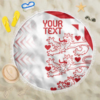 White round beach blanket with red custom text, lion pattern, and fringed border