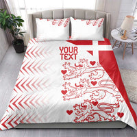 White and red bedding set on bed with two pillow shams; chevrons and lion hearts print