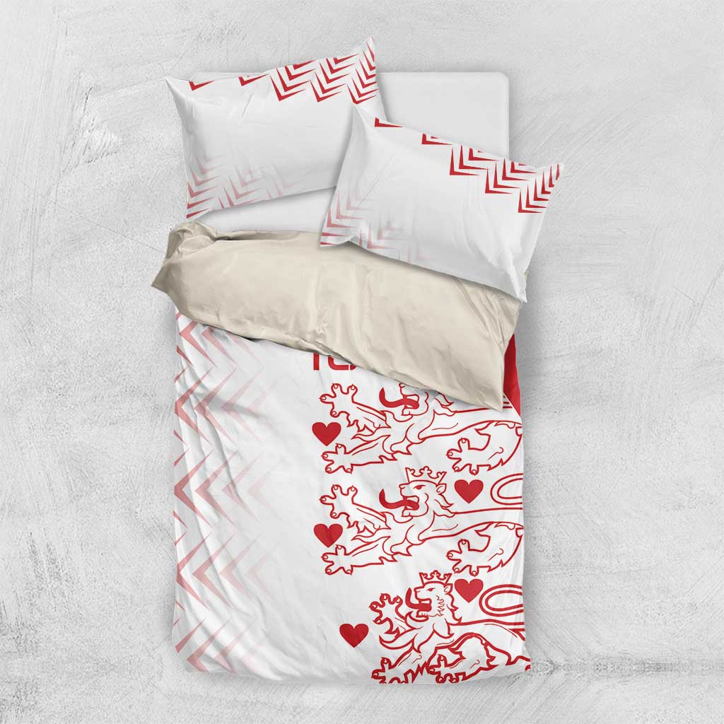 White bedding set with red lion-and-heart print and chevron accents, including two shams
