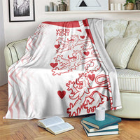 Red and white Denmark football blanket spread across couch with lions and hearts