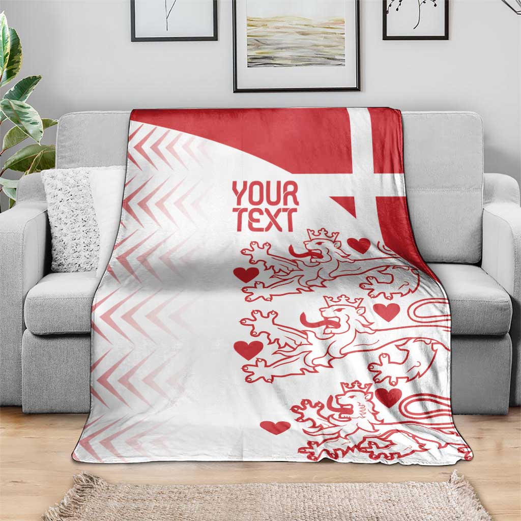 Red and white Denmark football blanket draped on gray sofa, geometric diagonal edge