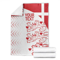 Folded red and white Denmark football blanket with lions, hearts, and red text area