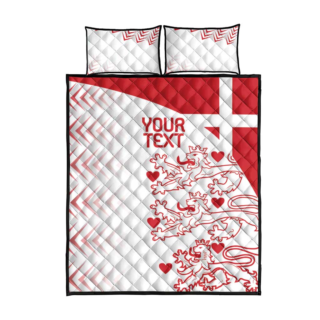 White quilt bed set with two pillows, red crest, and zigzag trim; black edges